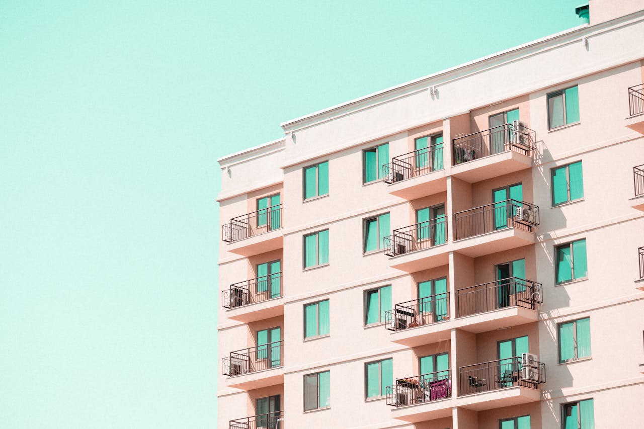 Modern apartment building facade with balconies under a clear blue sky.